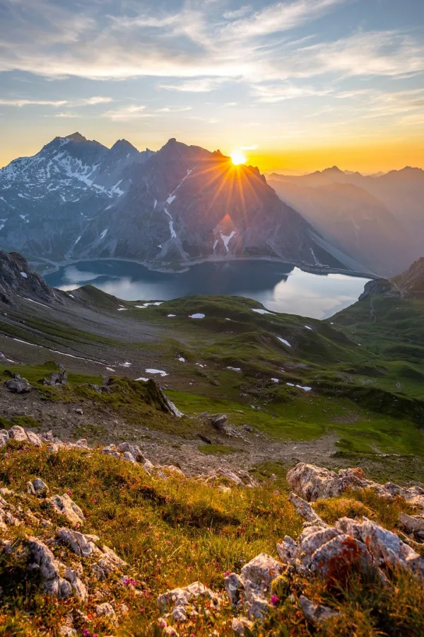 Lever de soleil sur un lac de montagne entouré de sommets majestueux