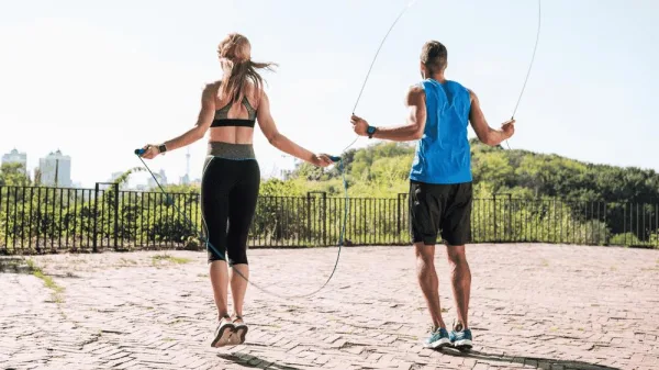 Deux sportifs faisant de la corde à sauter en extérieur