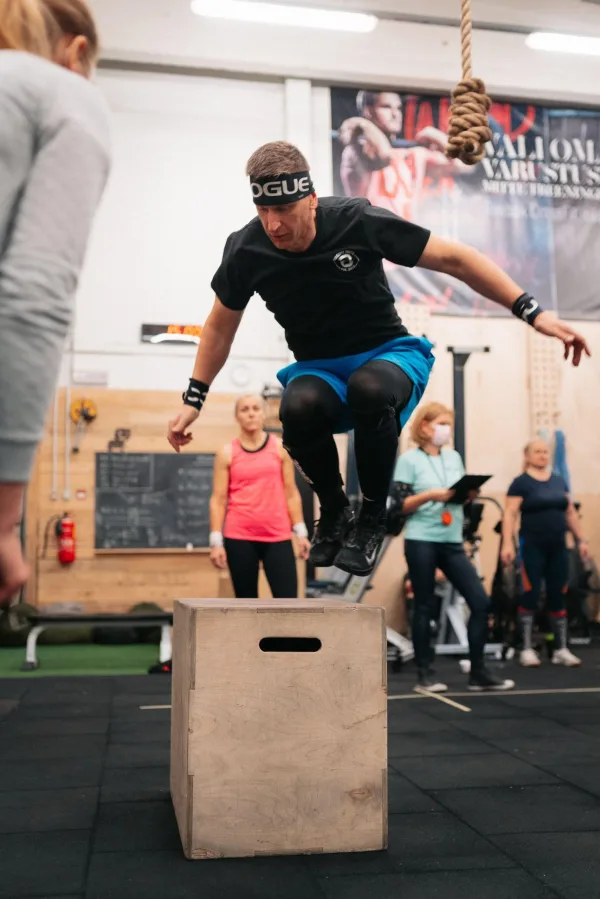 Athlète réalisant un saut sur caisse pliométrique en salle de sport