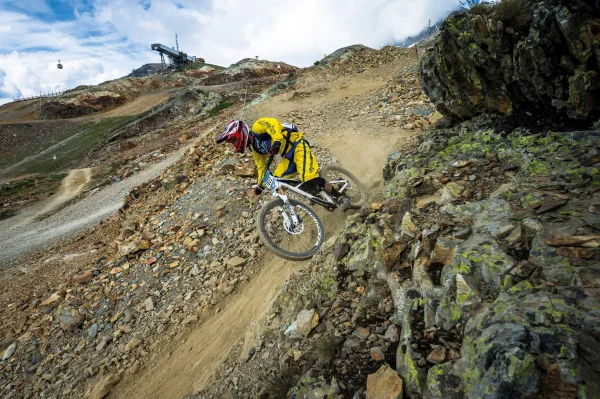 Cycliste de descente VTT sur un sentier rocheux en montagne