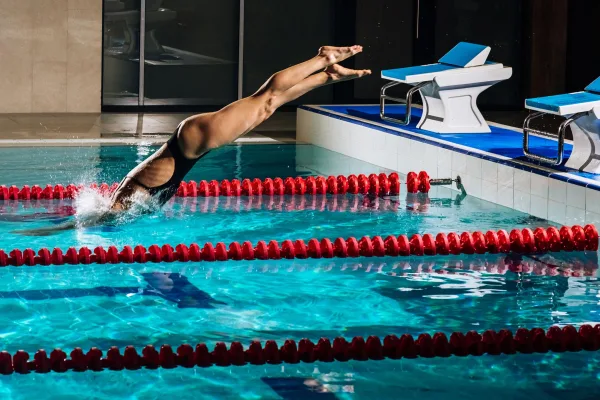 Nageuse plongeant dans une piscine olympique lors d'un entraînement