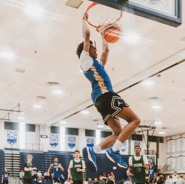 Joueur de basketball réalisant un dunk spectaculaire en plein match