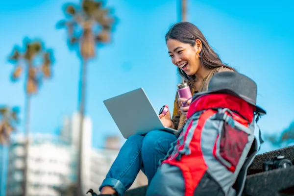 Jeune nomade digitale travaillant sur son ordinateur portable en plein air