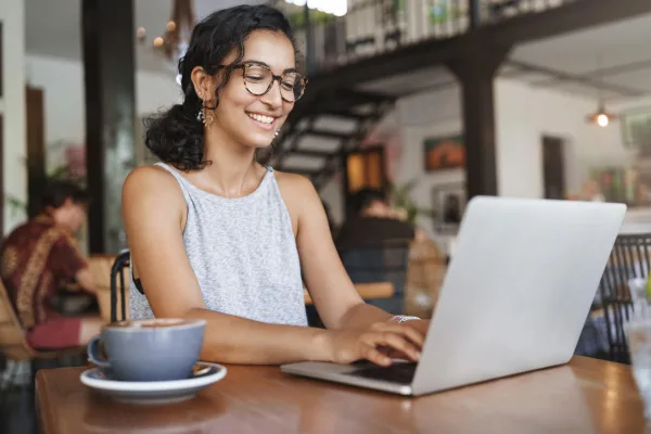 Jeune femme freelance travaillant sur son ordinateur portable dans un café moderne