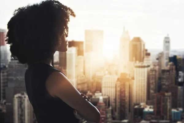 Femme d'affaires contemplant l'horizon urbain, symbole d'ambition, de confiance en soi et de vision d'avenir