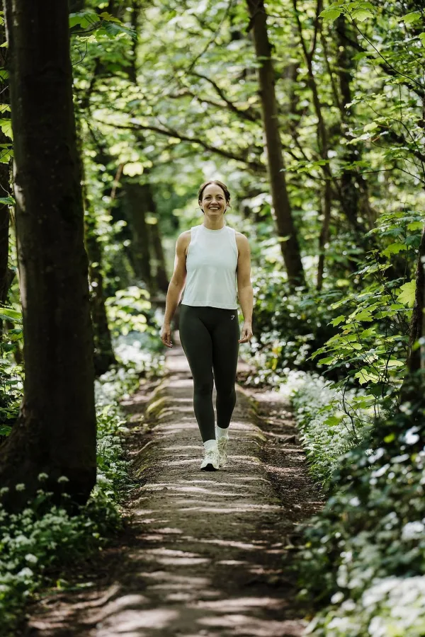 Femme marchant en forêt, symbole de bien-être, de confiance en soi et de développement personnel