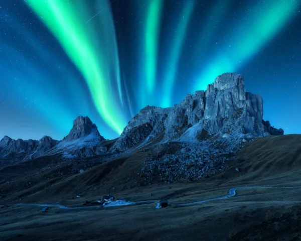 Aurores boréales illuminant un massif montagneux sous un ciel étoilé