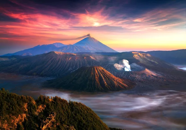 Paysage volcanique au lever du soleil avec cratères fumants et montagnes majestueuses