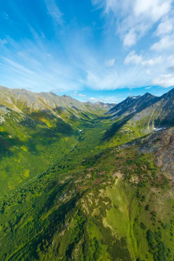 Vallée de montagne verdoyante vue aérienne sous un ciel bleu spectaculaire