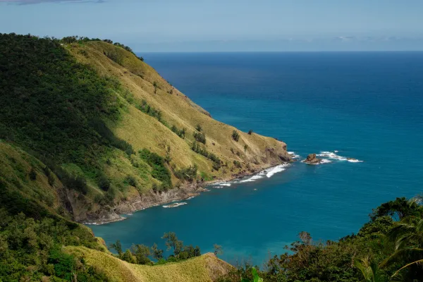 Vue panoramique d'une côte tropicale avec falaises verdoyantes et mer turquoise