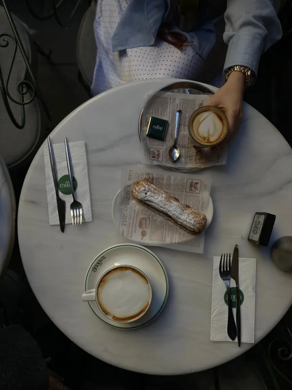 Petit-déjeuner gourmand dans un café avec cappuccinos et pâtisserie sur une table en marbre