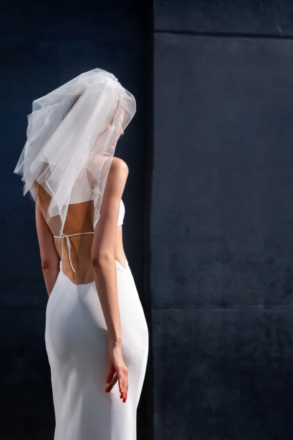 Mariée en robe blanche avec voile élégante vue de dos